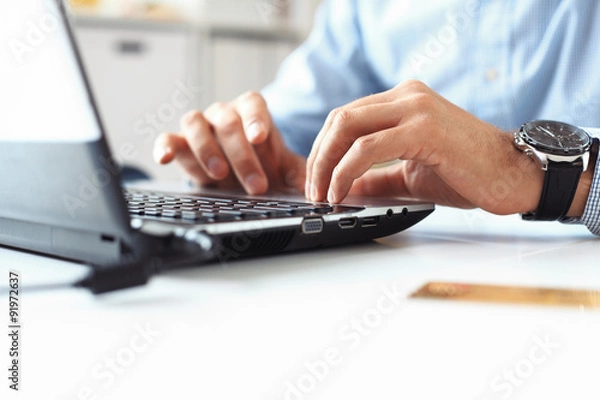 Obraz Close-up of male hands typing on laptop keyboard