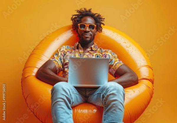 Obraz Man on inflatable chair, working on laptop