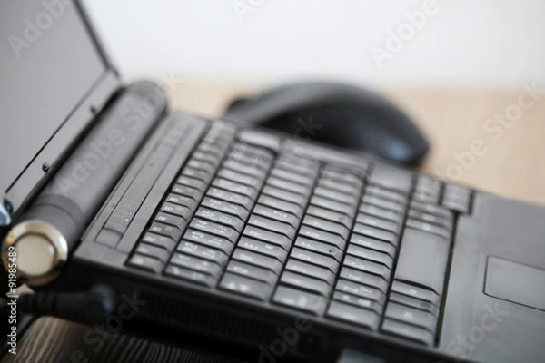 Obraz Office workspace with black laptop and mouse