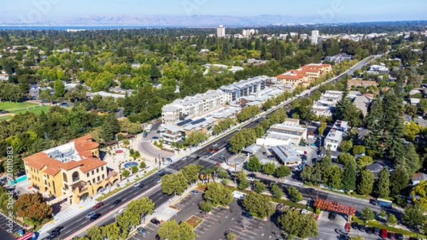Fototapeta Aerial view of commercial and residential areas of Menlo Park, California toward Palo Alto along El Camino Real Road near Middle Avenue. Backdrop distant San Francisco Bay and mountains