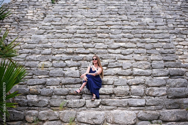 Fototapeta woman tourist in complex of mayan pyramids with wide impressive steep stairs in ancient city lost in the tropical jungle of Yucatan
