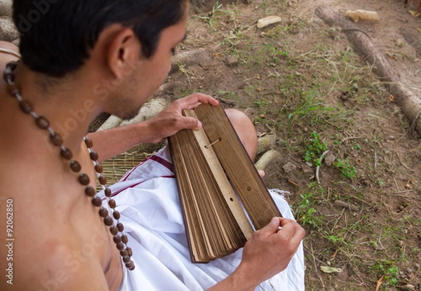 Obraz A young brahmin reads an ancient Hindu text under a banyan tree in India 
