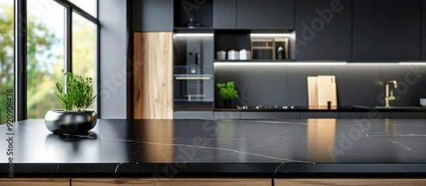 Fototapeta Black marble kitchen countertop with black cabinets and dark tiles in the background
