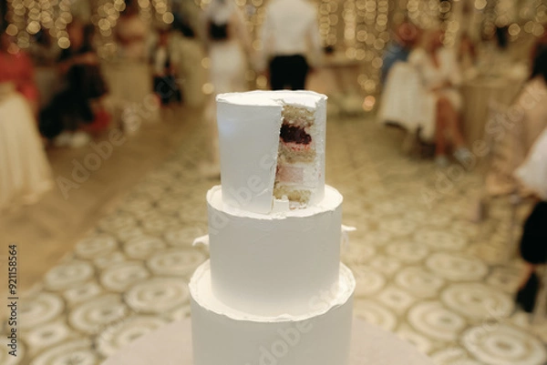 Obraz Cut a slice off a beautiful white wedding cake.