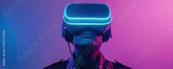 Fototapeta A man using a VR device facing up with a purple background