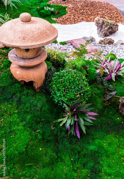 Fototapeta Minimal Japanese garden in home with small stone lantern and bamboo fountain and moss and flowers.
