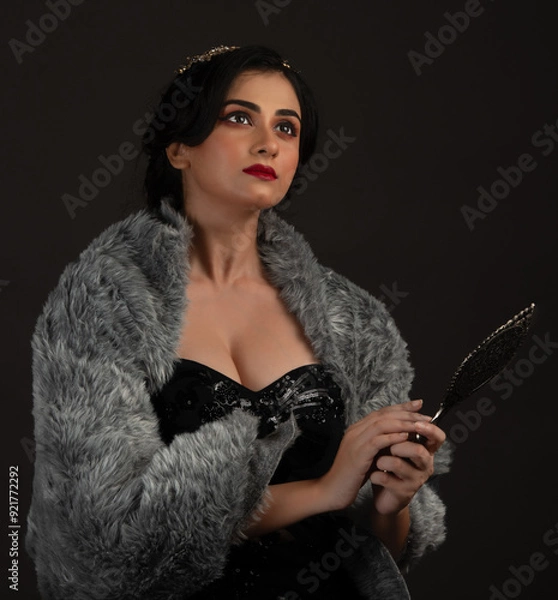 Fototapeta A beautiful lady dressed in retro look against a dark background.