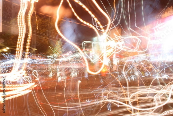Fototapeta The random flashes of light from vehicle lighting and street lamps create a beautiful abstract expression.