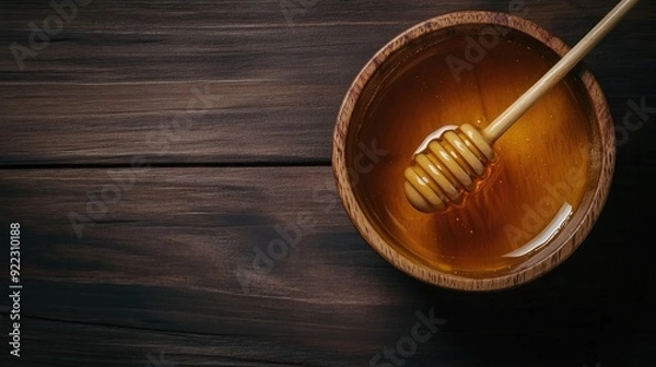 Fototapeta Organic Luxury: Pure Manuka Honey with Honey Dipper on Dark Wooden Surface