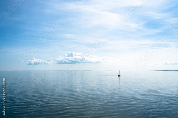 Fototapeta Sailboat against a dreamy blue sea and sky. Photo taken on the Baltic Sea with distant views of Hiiumaa Island, Estonia
