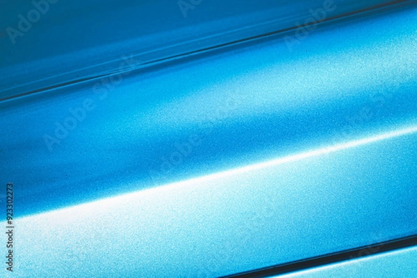 Obraz A blue car with a shiny paint job. The car is parked in a parking lot