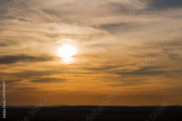 Obraz Sunset sky and the sun setting in thin clouds