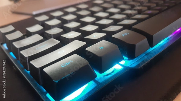 Obraz Close-Up of Backlit Mechanical Keyboard Showcasing Textured Keycaps and Bright LED Lighting. Ideal for Gaming or Office Use with Smooth Typing and Stylish Design.