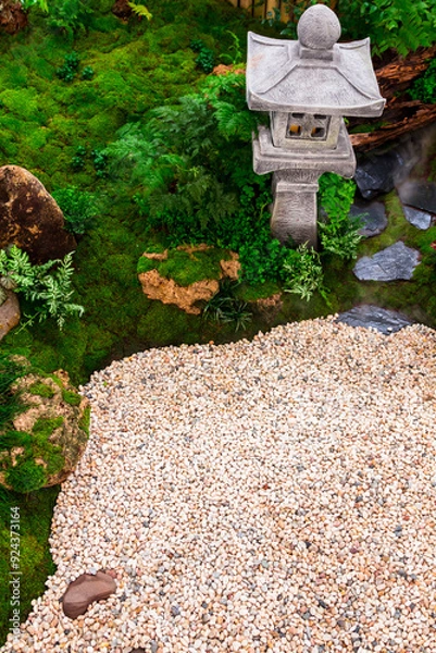 Fototapeta Minimal Japanese garden in home with small stone lantern and bamboo fountain and moss and flowers.
