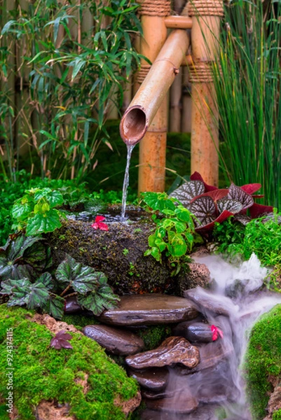 Fototapeta Minimal Japanese garden in home with small stone lantern and bamboo fountain and moss and flowers.
