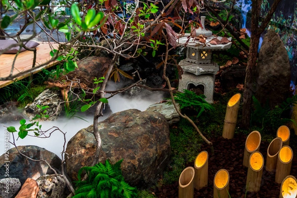 Fototapeta Minimal Japanese garden in home with small stone lantern and bamboo fountain and moss and flowers.
