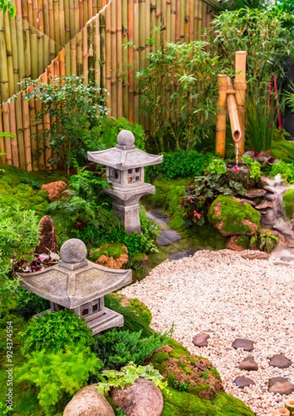 Fototapeta Minimal Japanese garden in home with small stone lantern and bamboo fountain and moss and flowers.

