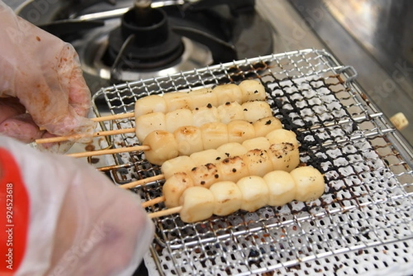 Obraz 両手でつまむ調理中の団子