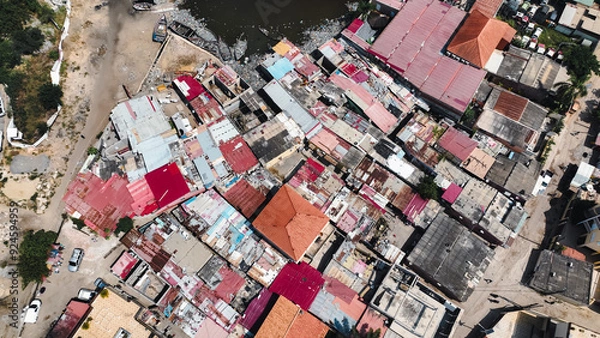 Fototapeta Aerial view of the slums in Luanda, Angola showcasing colorful rooftops and the river landscape beneath