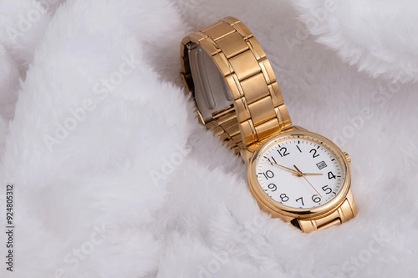 Obraz Luxury wristwatch made of a gold-toned metal on a white background, with depth of field. Close-up
