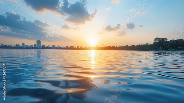 Obraz Serene Sunset Over Glistening Water with City Skyline in Distance