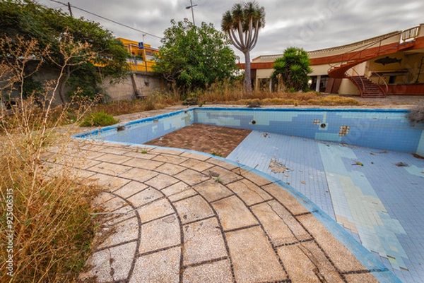 Fototapeta Abandoned swimming pool and vandalized abandoned hotel. Graffiti on the pool. Abandoned garden. Tenerife, Bajamar, Canary Islands.
