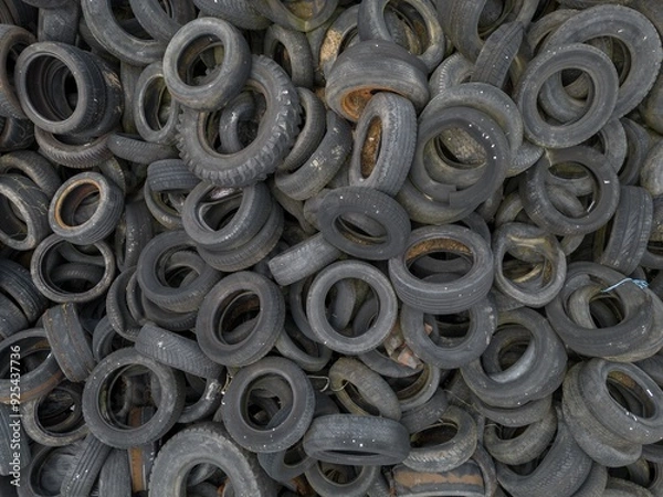 Fototapeta Dump recycling Pile heap stack old used vintage car tyres tires wheels waste dump with some leaves and mud dirt