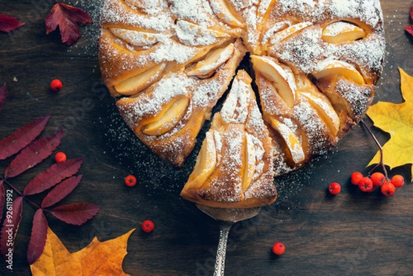 Fototapeta Fresh baked apple pie on the wooden table with autumn leaves around