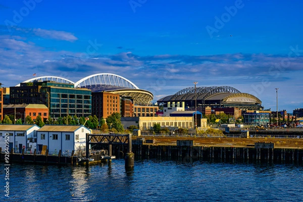 Obraz 2024-08-15 VIEW OF THE WATERFRONT PIERS ALONG ELLIOTT BAY WITH THE SOD AREA AND THE BASEBALL AND FOOTBALL STADIUMS IN SEATTLE WASHINGTON