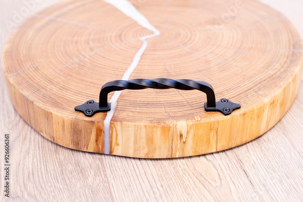 Fototapeta Kitchen board. Wooden tray made of oak and epoxy resin. Wood texture and annual rings. End section of the trunk. On the background.