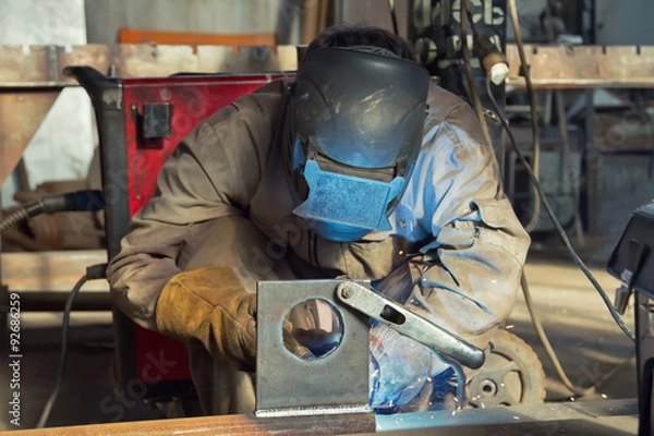 Obraz A welder fabricates steel structures using semi-automatic weldin