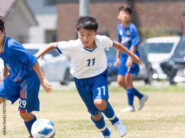 Fototapeta サッカーの試合をする小学生の男の子
