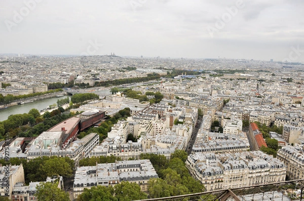 Fototapeta Streets of Paris from the height of the Eiffel Tower. Seine River. Rooftops of Parisian houses.