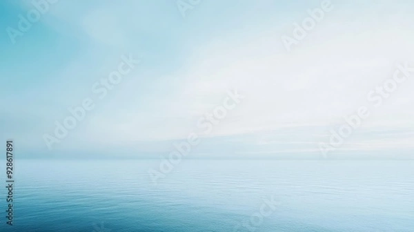 Fototapeta A serene view of a calm ocean under a soft blue sky.