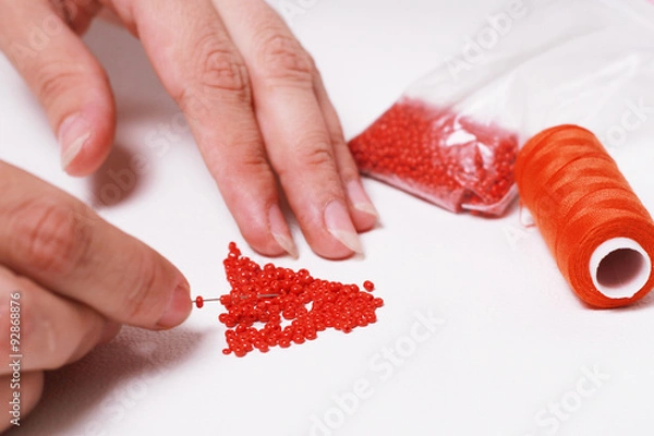 Fototapeta Stringing beads on a needle
Нанизывание бисера на иголку