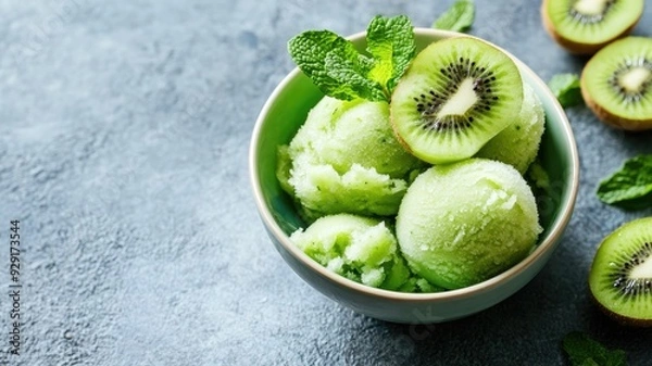 Obraz Refreshing kiwi sorbet served in a bowl with fresh mint leaves, perfect for a summer treat.