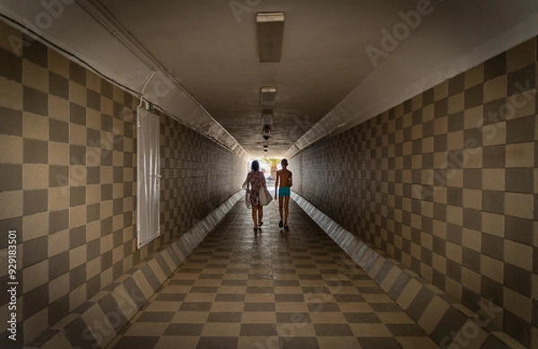 Obraz mother and son goes to the beach through the tunnel