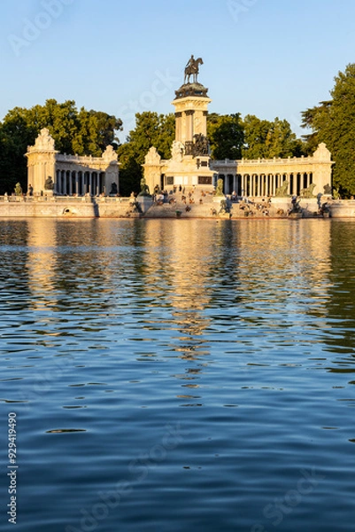 Fototapeta Retiro Park, Madrid, Spain. Crystal Palace, lake with swans, glass structure, architecture. Lake and temple on the horizon, fountains and decorated with colorful plants and flowers, family leisure.