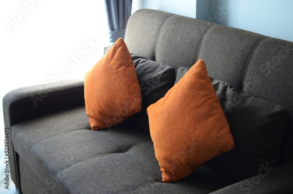 Obraz Gray sofa and orange cushions There was light shining beside the door.