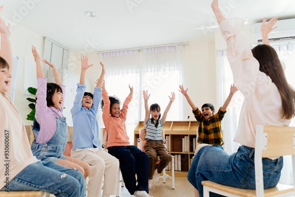 Obraz Excited primary school kids from various backgrounds express happiness together. Cheerful classroom scene captures essence of modern education, highlighting unity and active participation