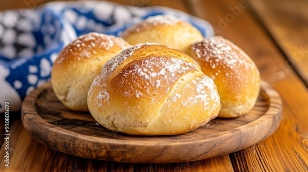 Fototapeta A plate of four small, round, powdered doughnuts sits on a wooden table