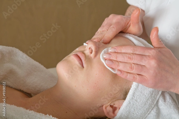 Fototapeta Closeup of human hands massaging a young pretty woman's face