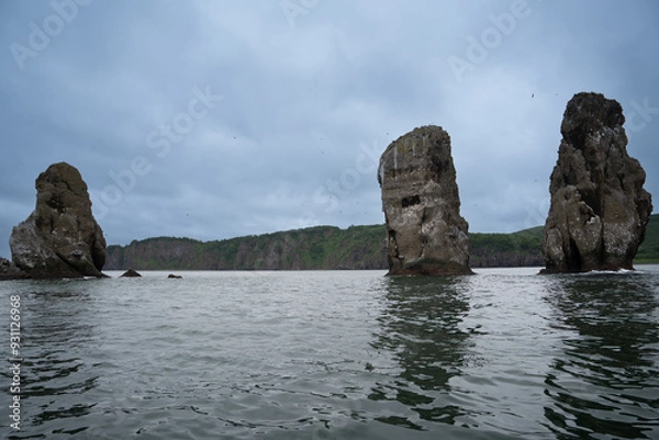 Obraz From the sea side there are Three brothers rocks in the Avacha Bay. In the background there are green mountains and hills.