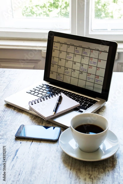 Fototapeta Checking monthly activities in the calendar in the laptop