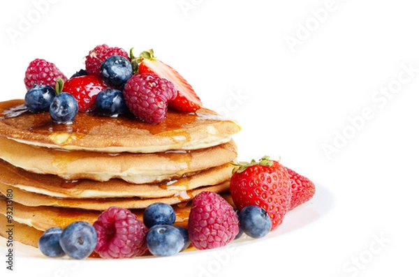 Fototapeta Pancakes with berries and honey over white