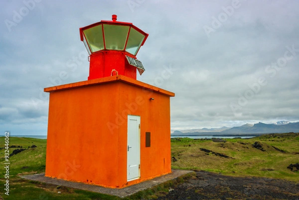 Fototapeta Small Orange Lighthouse nestled in the Icelandic Hills
