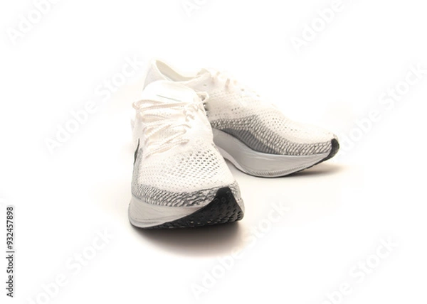 Fototapeta White racing shoes with black outsole rubber waffle pattern isolated on white background, upper mesh with breathability around the toes box combined with soft, yet supportive yarns, clipping path