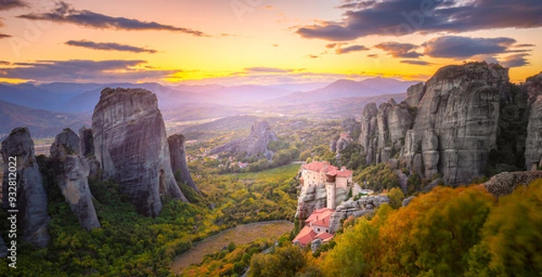Fototapeta Panoramic landscape of Meteora, Greece at romantic sundown time with real sun and sunset sky. Meteora - incredible sandstone rock formations.  The Meteora area is on UNESCO World Heritage.