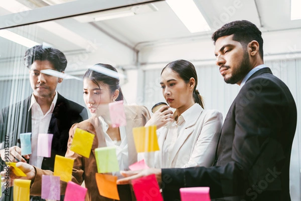 Obraz Group of successful Asian businessmen teamwork. Brainstorm meeting with sticky paper notes on the glass wall for new ideas. Using agile methodology for business in a tech start-up office.