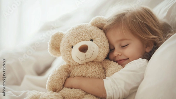 Fototapeta Close-up of a happy young child snuggling with a plush teddy bear, both dressed in matching pajamas, capturing the sweet bond between a kid and their beloved toy. photo
